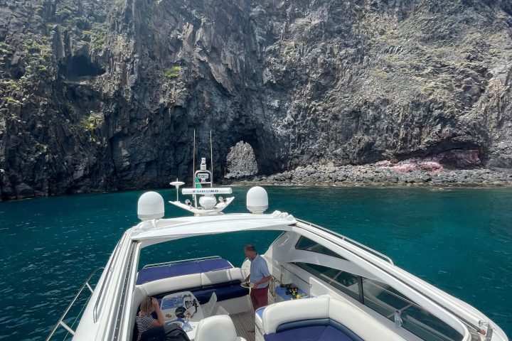 a small boat in a body of water with a mountain in the background