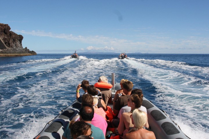 a group of people standing next to a body of water